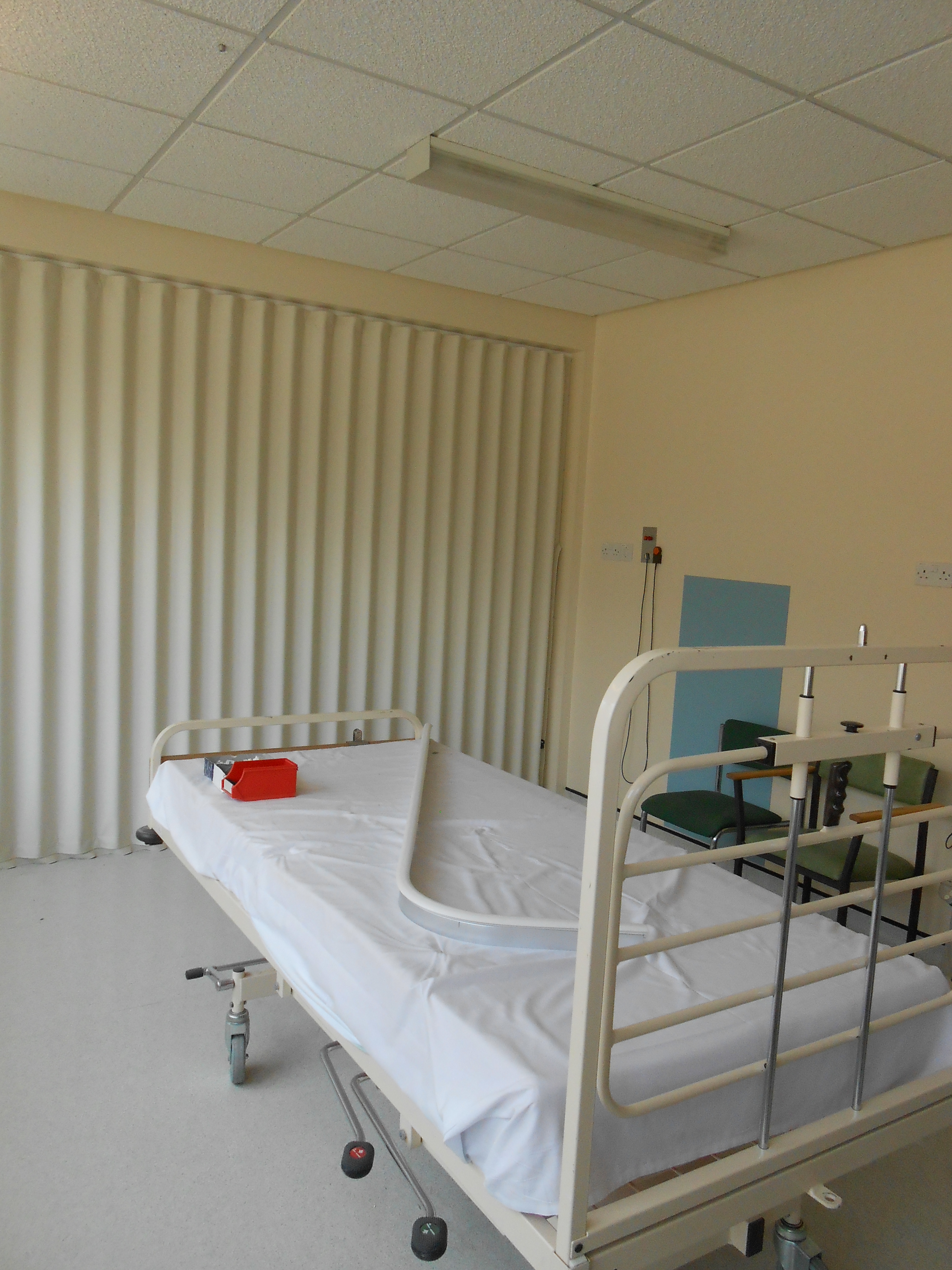 hospital bed with folding fabric room divider in white