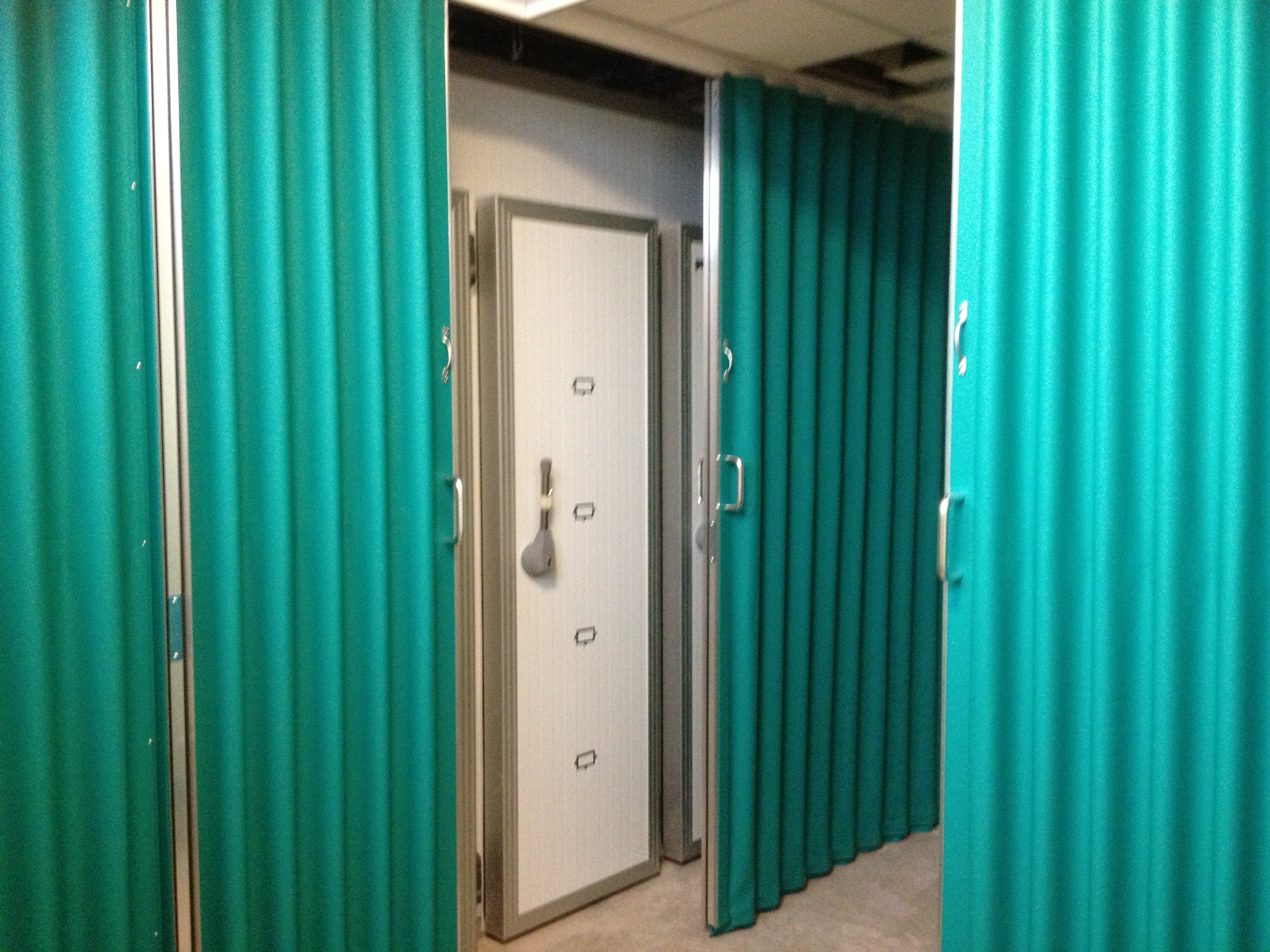 folding green fabric room divider in a hospital